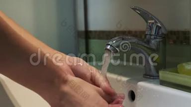 一个女人在浴室里用肥皂洗手，以<strong>消除细菌</strong>和防止病毒。 个人卫生